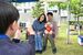 ペット防災手帳の表紙を撮影する参加者=24日午後、県庁前広場