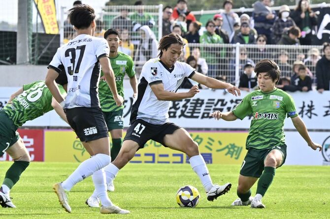 前半、栃木SCのMF吉野(中央)が相手選手に囲まれながらドリブルする=青森県八戸市のプライフーズスタジアム