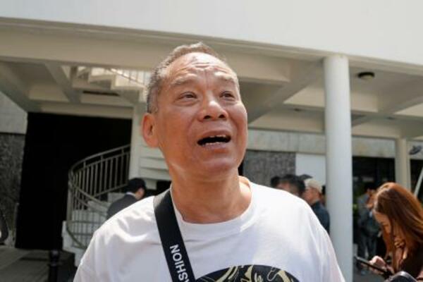 　傍聴後に報道陣の取材に応じる被災者の羅さん＝１９日、香港（共同）