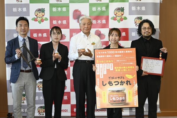 「ご飯にかけるしもつかれ」を手にする小川社長、篠原さん、福田知事、石井さん、青柳代表（左から）＝８日午後、県庁