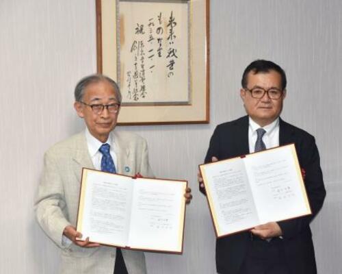 全国大学生協連と連携協定書を交わした「ノーモア・ヒバクシャ記憶遺産を継承する会」の浜住治郎さん(左)=22日午後、東京都杉並区