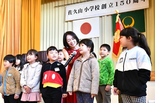 シンガー・ソングライターのすわさん（中央）と一緒に歌う児童