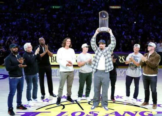 レーカーズ戦のコートに登場し、優勝トロフィーを掲げるドジャースのスネル=5日、ロサンゼルス(ゲッティ=共同)