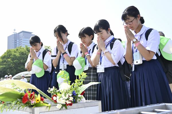 慰霊碑の前で手を合わせる栃木市の中学生たち＝６日午前９時35分、広島市