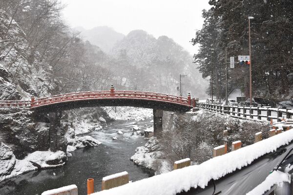 雪が降り積もる神橋付近＝２５日午前１０時４５分、日光市上鉢石町