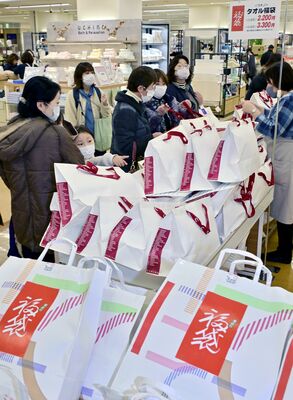 福袋を品定めする買い物客たち