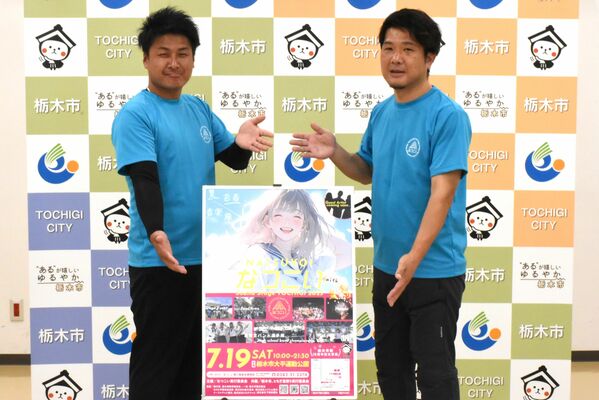 なつこいのポスターを手に来場を呼びかける川田実行委員長（右）