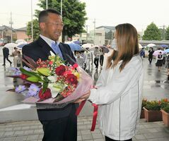 笑顔で支援者から花束を受け取る星野町長（左）