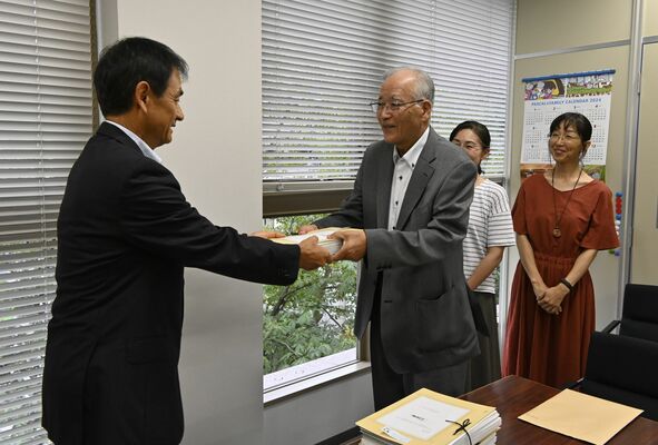 阿久澤県教育長（左）に署名を手渡す宇田会長＝22日午後、県庁南別館