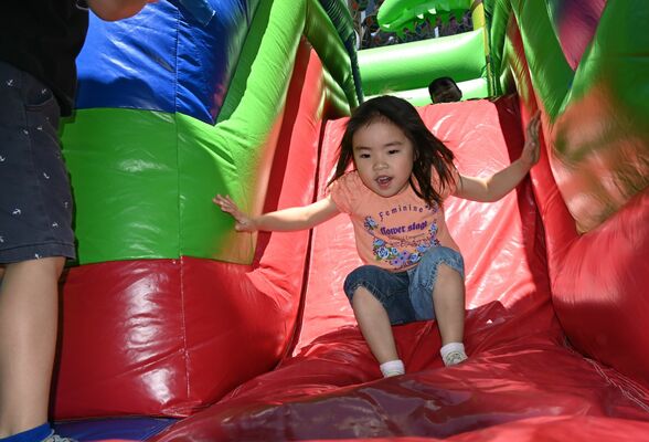 「ふわふわジャンボエアーポリン」内の滑り台を楽しむ子ども