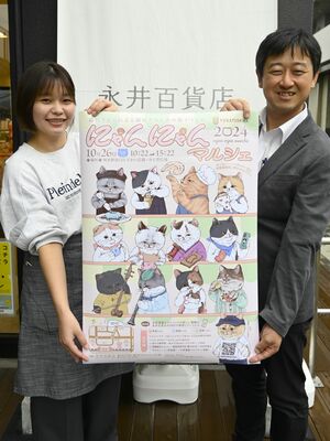 にゃんにゃんマルシェのポスターを持つ大学店長（左）