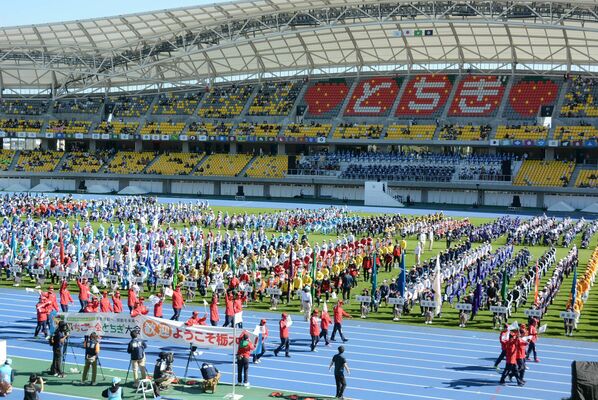 入場行進する選手たち。約２千人がフィールドに整列した＝29日午前10時25分、カンセキスタジアムとちぎ