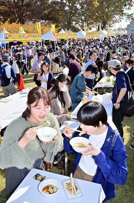 出来たてのギョーザを頬張る多くの来場者たち＝３日正午、宇都宮市本丸町