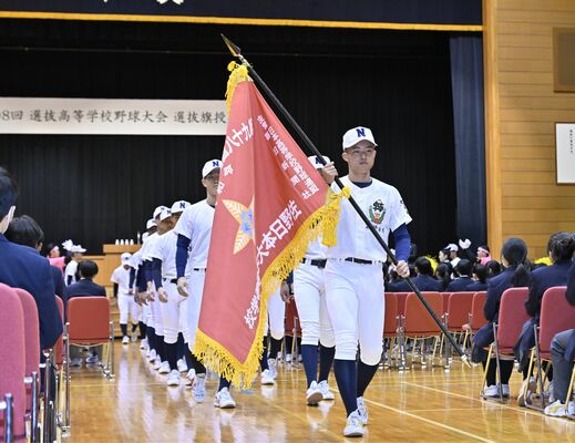 選抜旗を持つ中村主将を先頭に行進する佐野日大野球部の選手たち=佐野日大高プラザ40