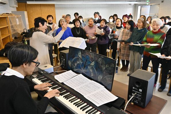 石田さん（左）の伴奏で合唱を練習する町民ら