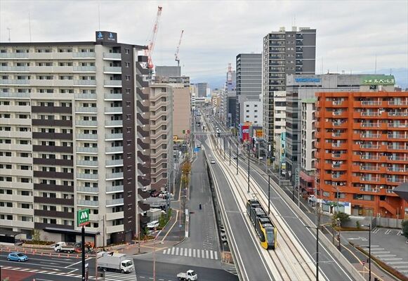 新築や建設中のマンションが林立する中、高架軌道を走るライトライン＝５日午前10時５分、宇都宮市峰１丁目