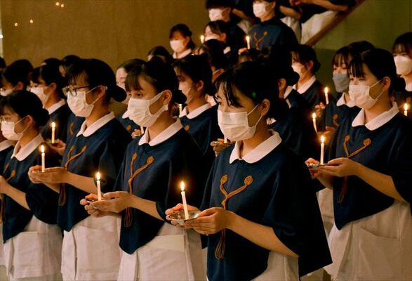 キャンドルを手にする看護学部の学生