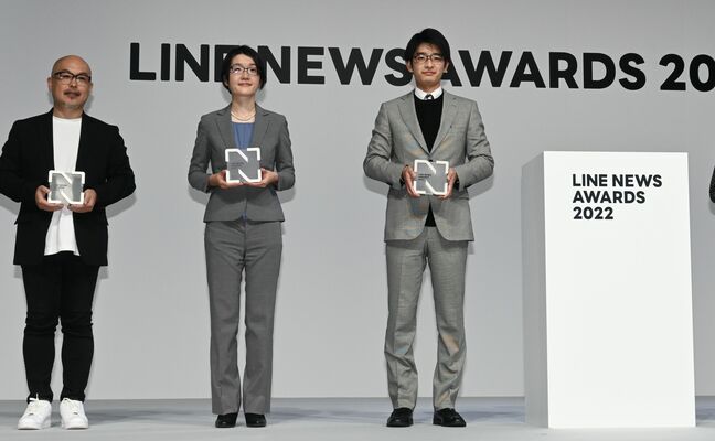 ＬＩＮＥニュースアワードで大賞のトロフィーを受け取った下野新聞社社員（右）＝１４日午後６時４０分、東京都内