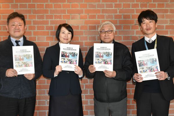 完成した事例集を持つ制作者たち（右から２番目が広瀬さん）