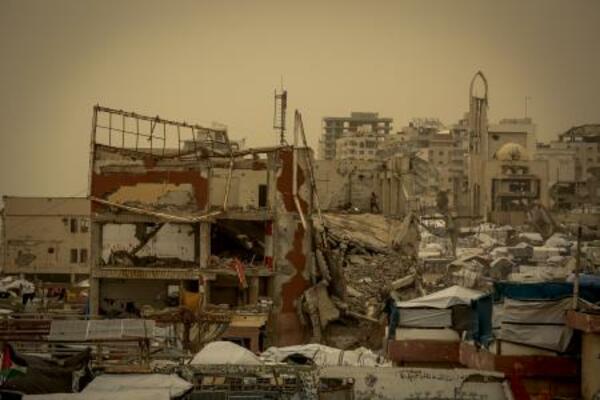 壊滅したガザの市街地と、砂嵐に見舞われた仮設テント=13日(ゲッティ=共同)