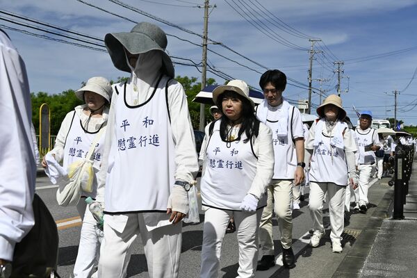 鎮魂と平和を願い、最後の激戦地を行進する坂田さん（中央）＝23日午前９時40分、沖縄県糸満市