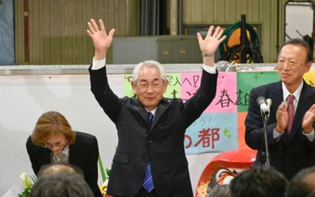 北海道寿都町長選で7選を果たし、万歳して喜ぶ現職の片岡春雄氏=28日夜、寿都町