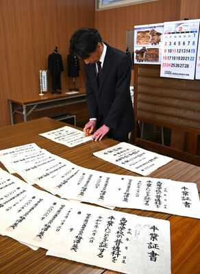 野州麻紙を使った卒業証書に印を押す鹿沼高の教員
