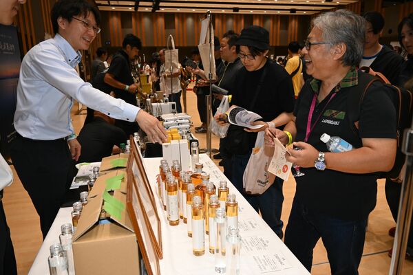 ウツノミヤ・スピリッツ・マルシェで愛好家に説明する西堀専務(左)=10月5日、宇都宮市