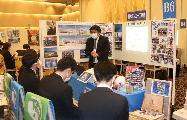 学生に事業内容などを説明する企業担当者＝１２日午後、宇都宮市内