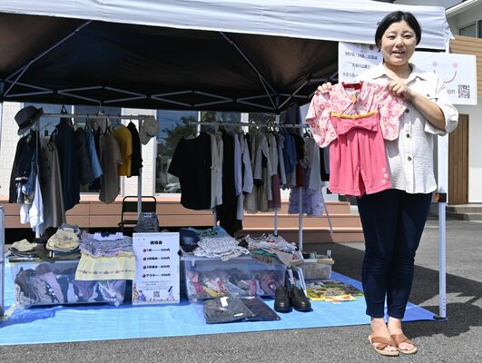 回収した子ども服を手にする須藤さん