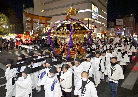 宇都宮二荒山神社の大鳥居をくぐって街なかを渡御するみこし＝15日午後５時30分、宇都宮市馬場通り２丁目