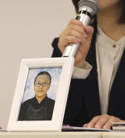 亡くなった男子生徒の遺影を前に、記者会見する母親=2024年