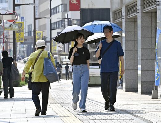 真夏日となった宇都宮市中心部で日傘を差して歩く親子＝24日午後２時50分、同市馬場通り１丁目