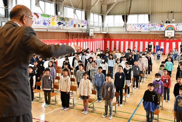 指揮に合わせて新校歌を歌う児童