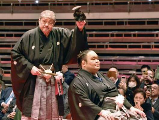 断髪式で師匠の錦戸親方(左)に最後のはさみを入れられた元幕内水戸龍=1日、東京・両国国技館
