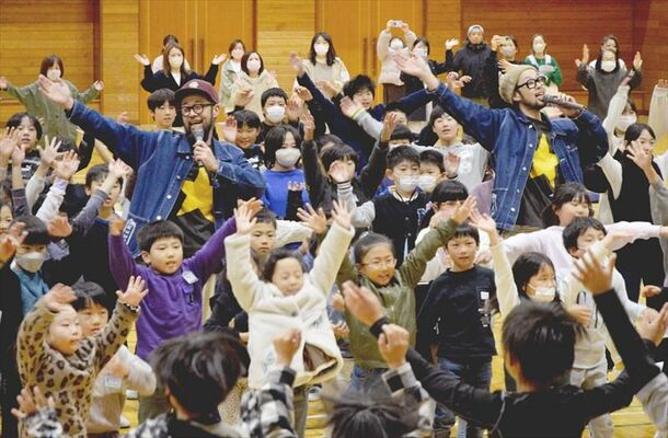 踊りながら歌う上鈴木兄弟と児童たち