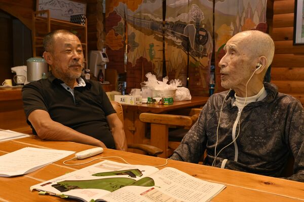 自身の戦争体験を雅章さん（左）に話す水野允氏さん＝８月上旬、塩谷町上寺島