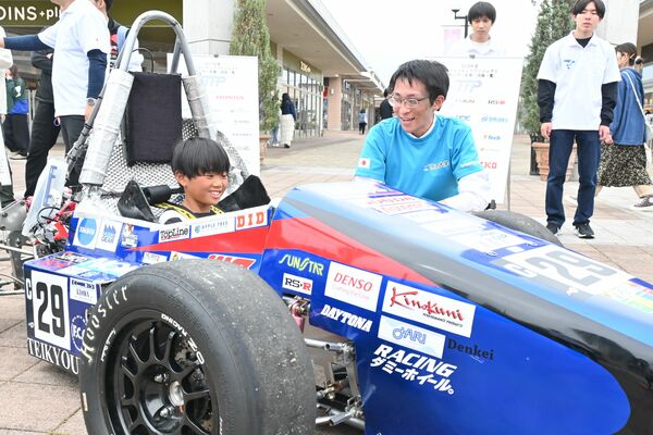 帝京大生が製作したフォーミュラカーに乗る来場者＝29日午後、宇都宮市インターパーク４丁目
