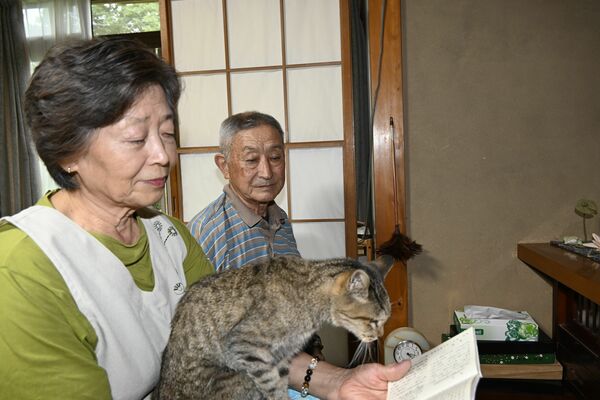 仏前に座る繁子さんの膝の上に乗るはじ