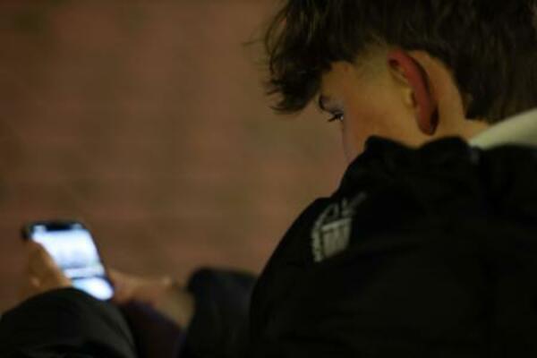 　３日、スペイン・マドリード郊外で、スマートフォンの画面をスクロールする１４歳の子ども（ロイター＝共同）