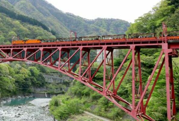 　運行を再開し、鉄橋を渡る黒部峡谷鉄道のトロッコ電車＝２０日午前、富山県黒部市
