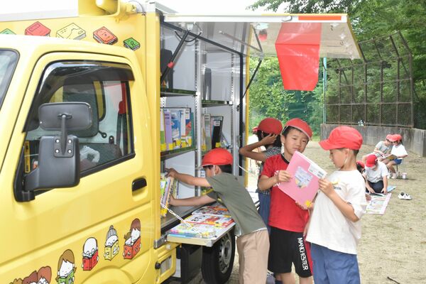 移動図書館車から本を選ぶ児童たち