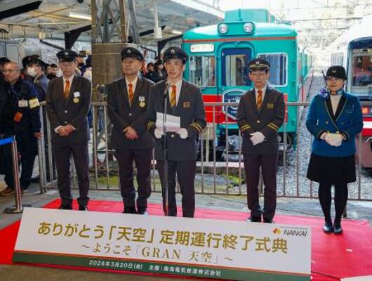 南海電鉄極楽橋駅で開かれた、観光列車「天空」(奥)の定期運行終了式典=20日午後、和歌山県高野町