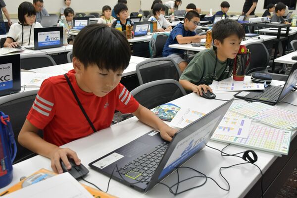 プログラミングで作品を作る子どもたち＝26日午後、県総合文化センター