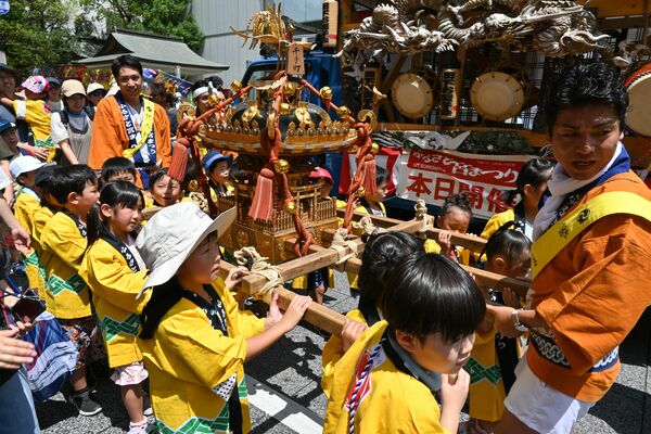 炎天下の中、元気にみこしを担ぐ子どもたち