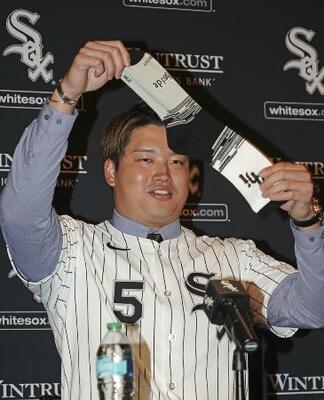 ホワイトソックスの入団記者会見で靴下を掲げる村上宗隆内野手=22日、シカゴ(共同)