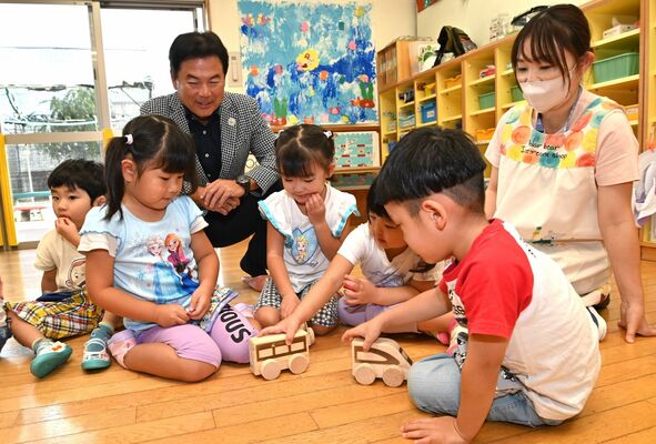 佐藤市長（左後方）から贈られた玩具で遊ぶ園児たち