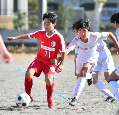 前半20分、ドリブル突破するＦＣファイターズのＭＦ高倉（左）＝陽北中