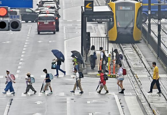 雨が降ったりやんだりする中、雨具を手に登校する小学生＝10日午前７時40分、宇都宮市宮みらい、永嶌理絵撮影