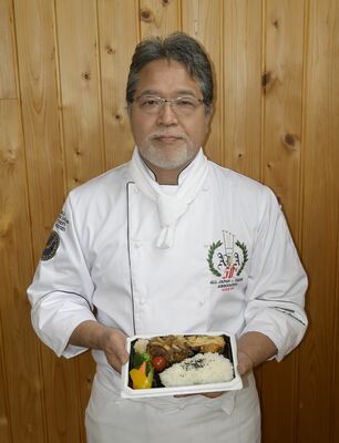 販売予定のハンバーグ弁当を手にする糸井さん